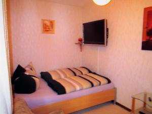 魏森斯塔特的住宿－Große Wohnung in Weißenstadt，墙上配有电视的房间里一张床位