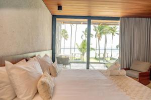 une chambre avec un grand lit avec une grande fenêtre dans l'établissement Anaya - Villas de Luxo, à Passo de Camarajibe 49 autres photos