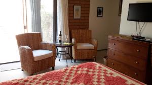 1 dormitorio con cama, sillas y mesa en Desert Trails Bed & Breakfast, en Tucson