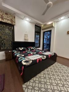 Home Away Home ( East Of Kailash ) New Delhi في نيودلهي: غرفة نوم بسرير كبير في غرفة