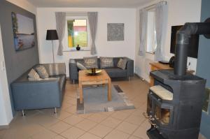 sala de estar con sofá y estufa de leña en Ferienhaus in Zislow mit Großem Kamin en Zislow