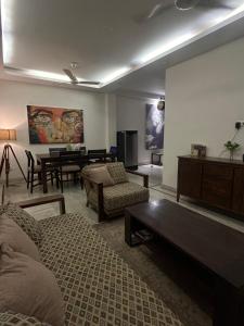 Home Away Home ( East Of Kailash ) New Delhi في نيودلهي: غرفة معيشة مع أريكة وطاولة