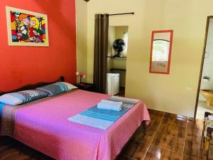 1 dormitorio con 1 cama con colcha rosa en Cachoeira do Roncador en São Francisco Xavier