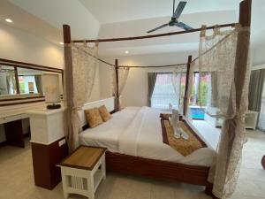 - une chambre avec un grand lit et un ventilateur de plafond dans l'établissement Villa Raya Resort Private Pool Villas, à Pattaya (nord)
