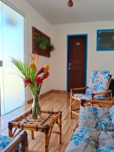 een vaas met bloemen op een tafel in een woonkamer bij Pousada Caminho do Mar in Paraty