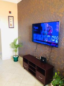 a living room with a flat screen tv on a wall at Maritah Homes in Kampala