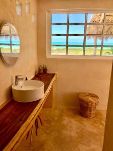 a bathroom with a sink and a window at La Casa del Sol Beachfront in El Cuyo