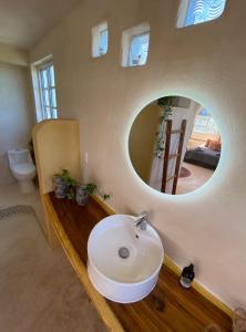 La salle de bains est pourvue d'un lavabo blanc et d'un miroir. dans l'établissement La Casa del Sol, à El Cuyo