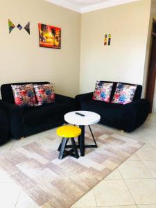 a living room with a table and a couch at Maritah Homes in Kampala