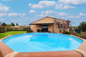 uma grande piscina em frente a uma casa em Villa au pied des Cévennes em Saint-Hilaire-de-Brethmas