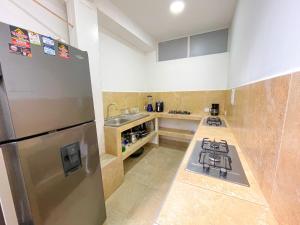 uma cozinha com um frigorífico de aço inoxidável e um lavatório em Casa Victoria em Montería