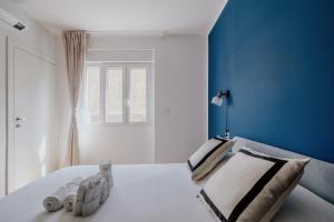 Dormitorio azul y blanco con cama y ventana en Elegante appartamento in Marina, en Trieste