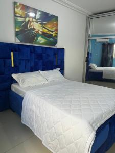 - une chambre avec un lit blanc orné d'une peinture murale dans l'établissement Lekker Estate, à Yaoundé