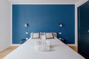 een blauwe slaapkamer met een groot wit bed met 2 kussens bij Elegante appartamento in Marina in Trieste