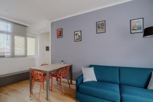 sala de estar con sofá azul y mesa en Elegante appartamento in Marina, en Trieste