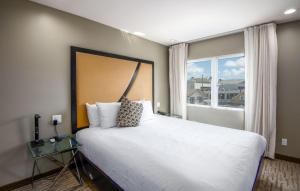 um quarto com uma cama grande e uma janela em Grandview Inn em Hermosa Beach