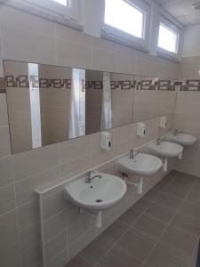 a bathroom with three sinks and a mirror at Penzion U Lipna in Přední Výtoň