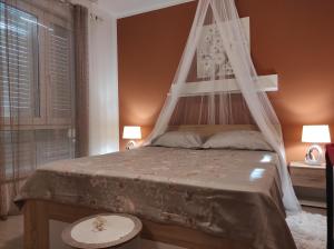 1 dormitorio con cama con dosel y ventana en Apartment Luka en Fažana