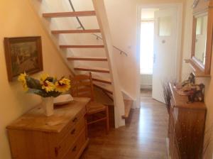 eine Treppe mit einer Blumenvase auf einer Kommode in einem Zimmer in der Unterkunft Ferienwohnung für sechs Personen - b56987 in Medebach + 14 Fotos