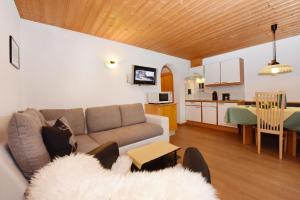 a living room with a couch and a kitchen at Wohnung in Galtür mit Kostenlosem Parkplatz in Galtür