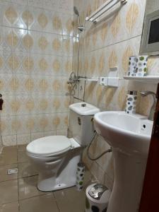 La salle de bains est pourvue de toilettes et d'un lavabo. dans l'établissement Lekker Estate, à Yaoundé