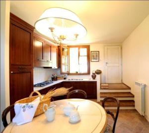 een keuken met een tafel met stoelen en een kroonluchter bij Große Ferienwohnung in Gambassi Terme mit Garten, Grill und Terrasse in Gambassi Terme