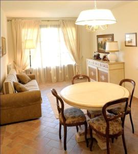 een woonkamer met een tafel en een bank bij Große Ferienwohnung in Gambassi Terme mit Garten, Grill und Terrasse in Gambassi Terme