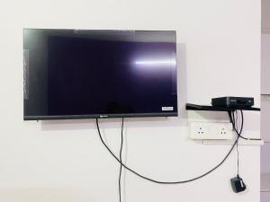 a flat screen tv sitting on top of a wall at Budget Private Ac Room with Kitchen Near Osho Garden in Pune