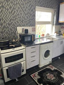 een keuken met een fornuis en een wasmachine bij Lovely Humuplace 1-Bed Apartment in Birmingham in Birmingham