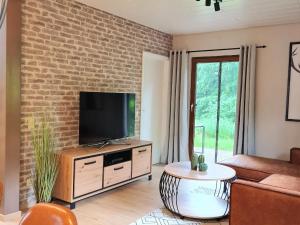 a living room with a flat screen tv on a brick wall at Tolles Ferienhaus in Kirchheim mit Schönem Garten in Kirchheim