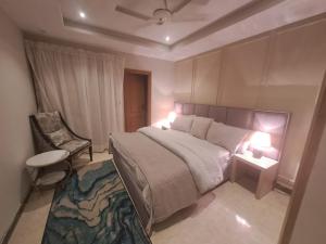 1 dormitorio con 1 cama grande y 1 silla en Sabs Residences, en Islamabad