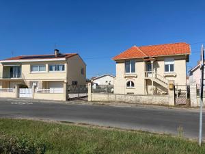a house with a fence next to a street at Les chambres du Phare - 3 chambres in Le Port-des-Barques