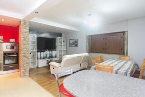 a kitchen and living room with a table and a bed at casa picota in Oia
