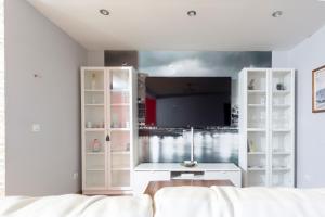 een woonkamer met een tv en een witte bank bij casa picota in Oia