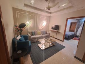 a living room with a couch and a table at Sabs Residences in Islamabad