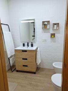 a bathroom with a sink and a mirror and a toilet at APARTAMENTOS SAN NICOLAS in Adra