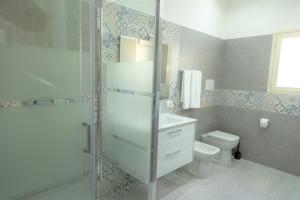 a bathroom with a toilet and a glass shower at Casa Vacanze Altea in Santa Flavia