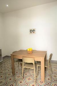 a dining room table with chairs and a bowl of fruit at Casa Vacanze Altea in Santa Flavia