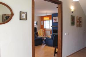 sala de estar con 2 sillas azules y mesa en Casa de Aldea Monga 9 en Nava, Asturias, en Nava