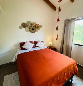 a bedroom with a bed with an orange blanket at TRANQUILA CASA DE PLAYA in Santa Cruz