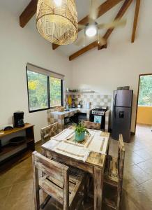 a kitchen with a wooden table with chairs and a refrigerator at TRANQUILA CASA DE PLAYA in Santa Cruz