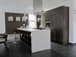 eine Küche mit einer großen weißen Insel in einem Zimmer in der Unterkunft Ferienhaus für 4 Personen ca 165 m in Mardorf, Norddeutschland Niedersachsen in Neustadt am Rübenberge