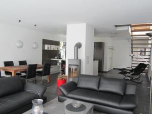 ein Wohnzimmer mit einem schwarzen Sofa und einem Tisch in der Unterkunft Ferienhaus für 4 Personen ca 165 m in Mardorf, Norddeutschland Niedersachsen in Neustadt am Rübenberge