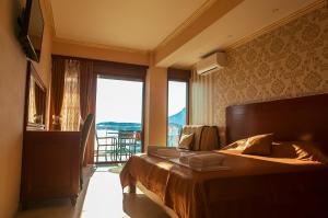 um quarto com uma cama e uma grande janela em Hotel Velkom em Sutomore