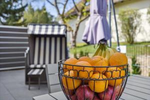 a bowl of oranges and bananas on a table at Gemütliches Ferienhaus am Plauer See mit Hund in Funfseen