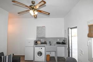 a kitchen with a washer and a ceiling fan at kleris apartment 11 in Tinos