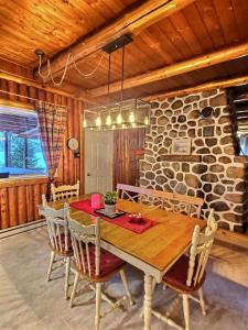 a dining room with a wooden table and chairs at Nelson Warm Log Cabin with Private Hot Tub in Rivière-Rouge
