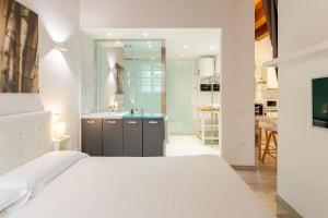 a bedroom with a white bed and a bathroom at Suite Martini al Castello in Cagliari