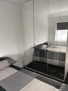 a bedroom with a glass partition with a bed at Impeccable Holiday House in London Sleeps four in London