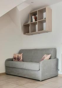 a gray couch in a living room with a shelf at Casa Bianca in Marina di Massa